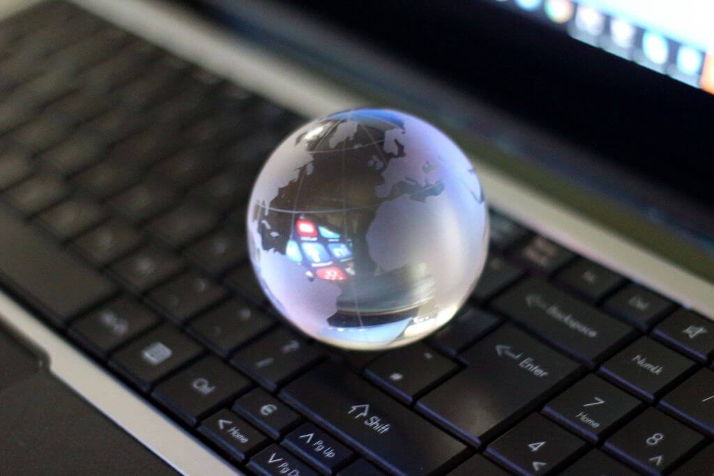 Clavier d'ordinateur accompagné d'un globe terrestre en verre